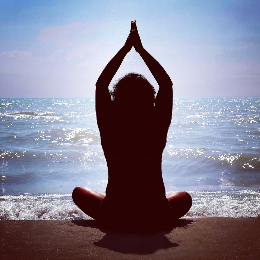 Sitting on the Beach Arms up, hands together in Prayer Position (Anjali Mudra)